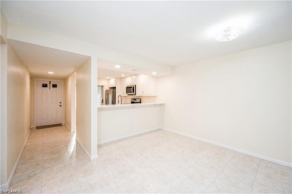 Unfurnished living room featuring recessed lighting and a sink