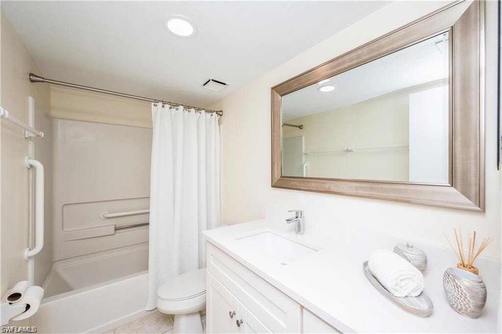 Bathroom featuring vanity, shower / bath combo with shower curtain, and recessed lighting