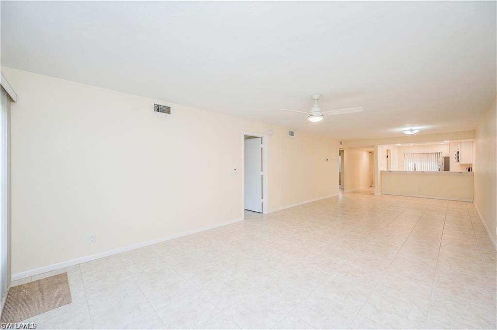 Unfurnished living room with a ceiling fan and baseboards