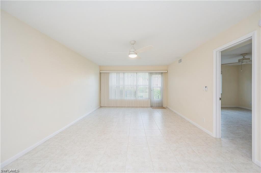Spare room with ceiling fan and light tile patterned floors