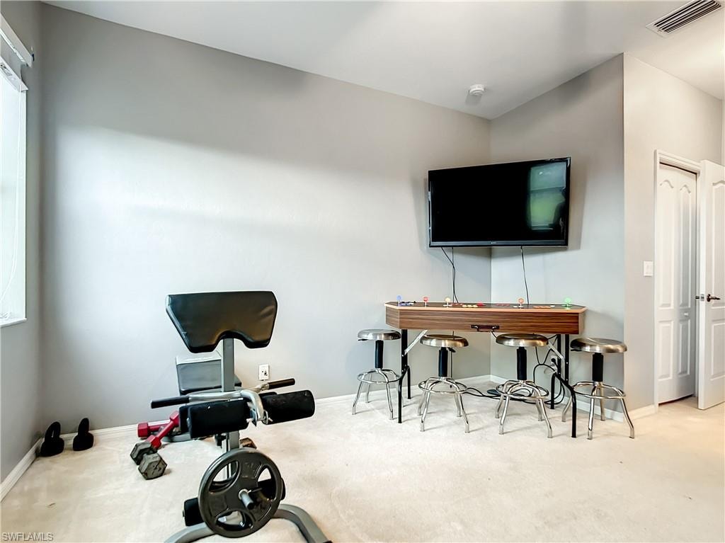 Carpeted room with light grey walls, featuring a window with blinds, and white bi-fold doors