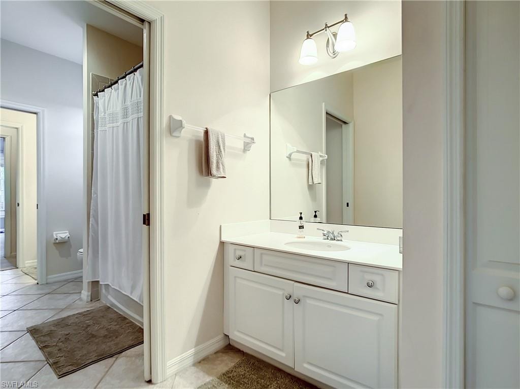 White vanity with integrated sink, chrome faucet, and overhead bar lighting