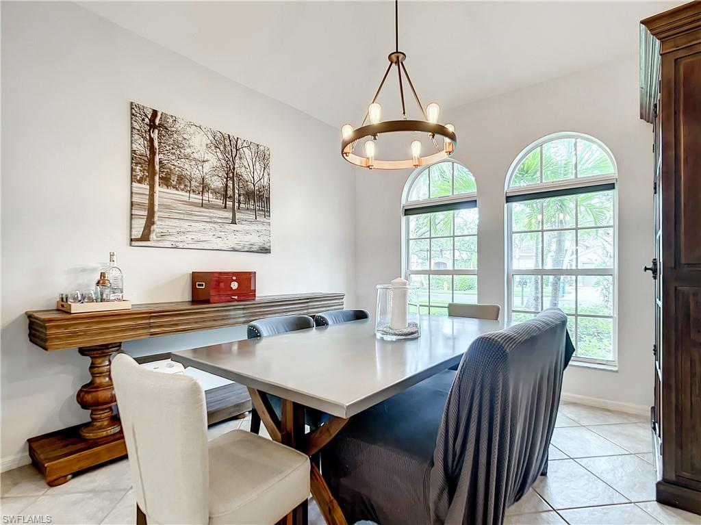 Arched windows, tile flooring, and a contemporary chandelier