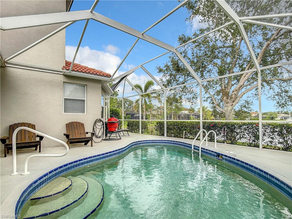 Screened-in pool with curved entry steps and a white railing