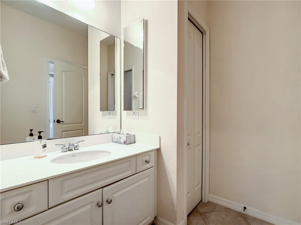 Vanity with a polished chrome faucet, an integrated sink, and white cabinetry