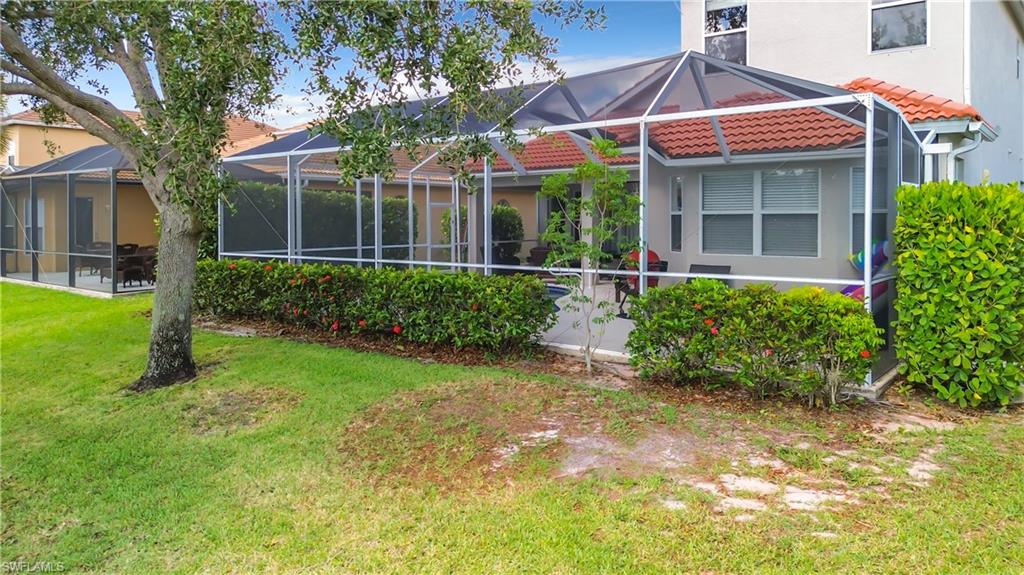 Screened patio with a tile roof extension and surrounding mature landscaping