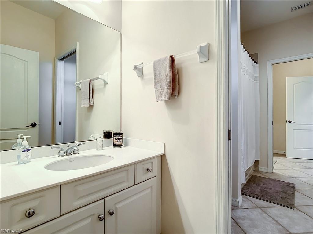 White vanity with an integrated sink, polished chrome faucet, and expansive wall-mounted mirror