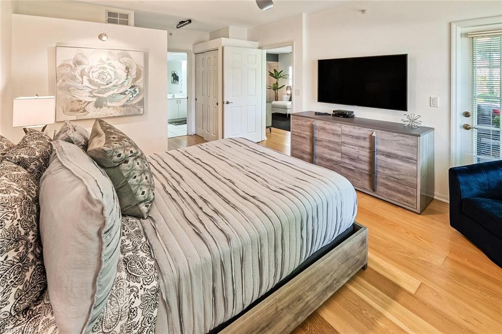 Bedroom featuring light wood-type flooring, connected bathroom, and access to exterior