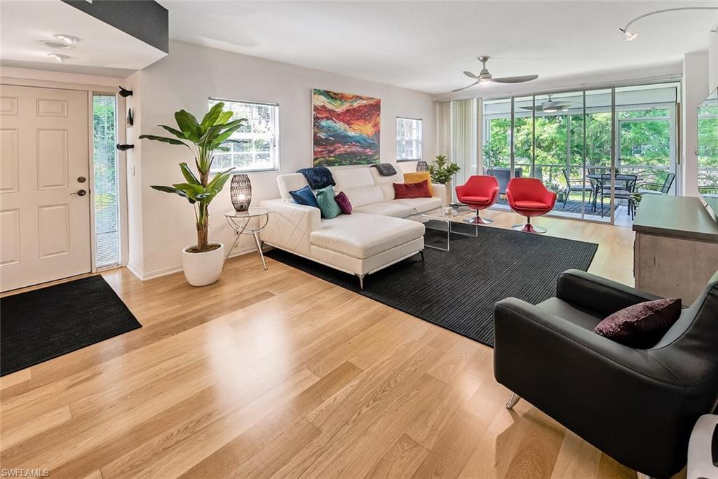 Living room with light hardwood / wood-style floors and ceiling fan