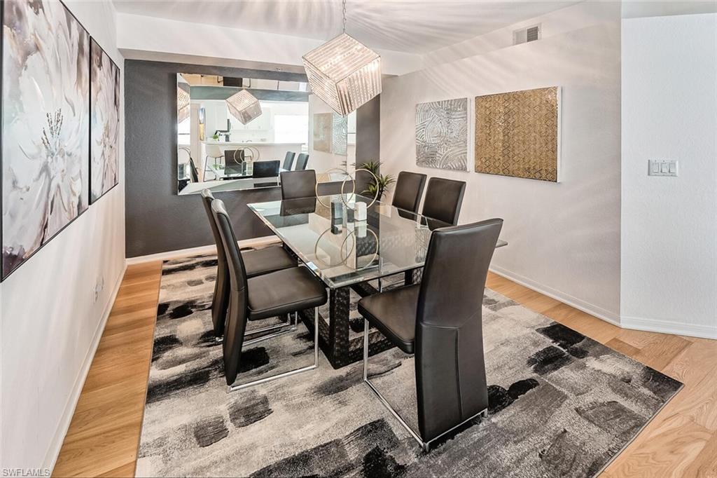 Dining area with vaulted ceiling and light hardwood / wood-style flooring