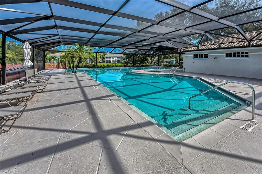 View of pool featuring glass enclosure and a patio area