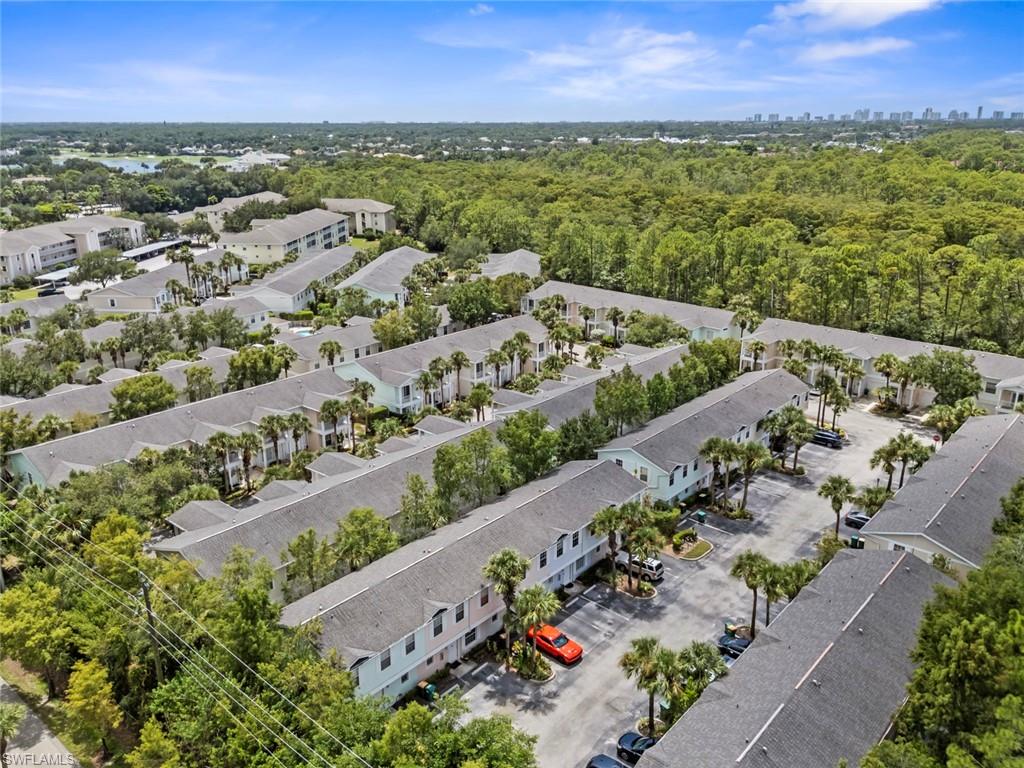 Expansive community with multiple residential buildings, surrounded by mature trees and natural landscaping