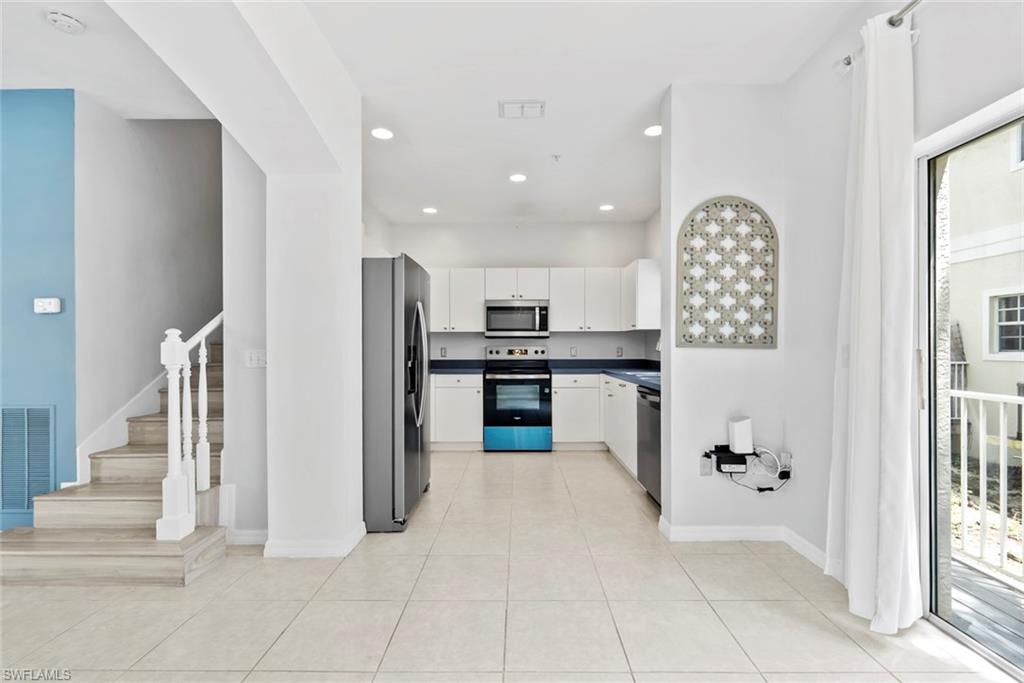 Open-concept kitchen with white cabinetry and dark countertops
