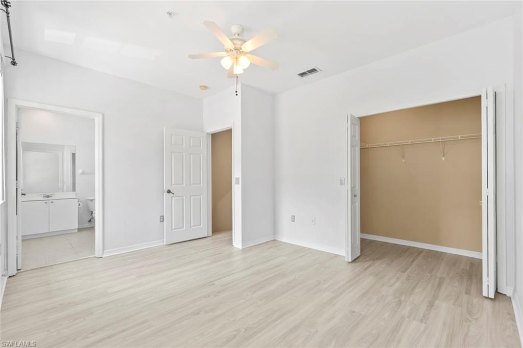 Light wood-finish flooring, ceiling fan with integrated lighting, recessed ceiling lighting, panel doors, and bi-fold closet doors
