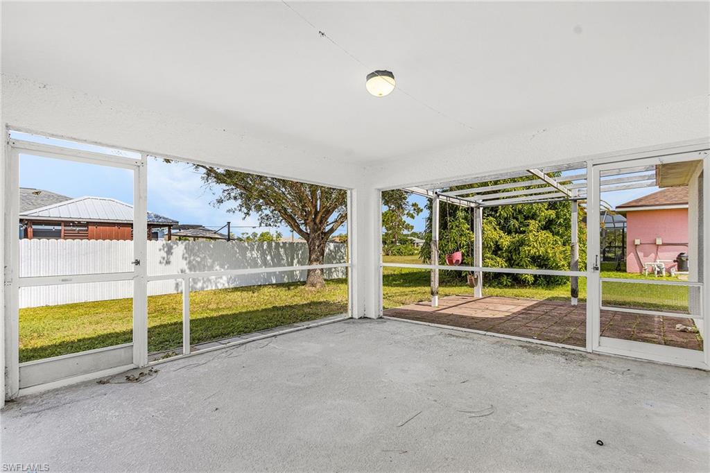 Screened-in patio with a concrete floor, overhead lighting, and an exterior brick paver patio