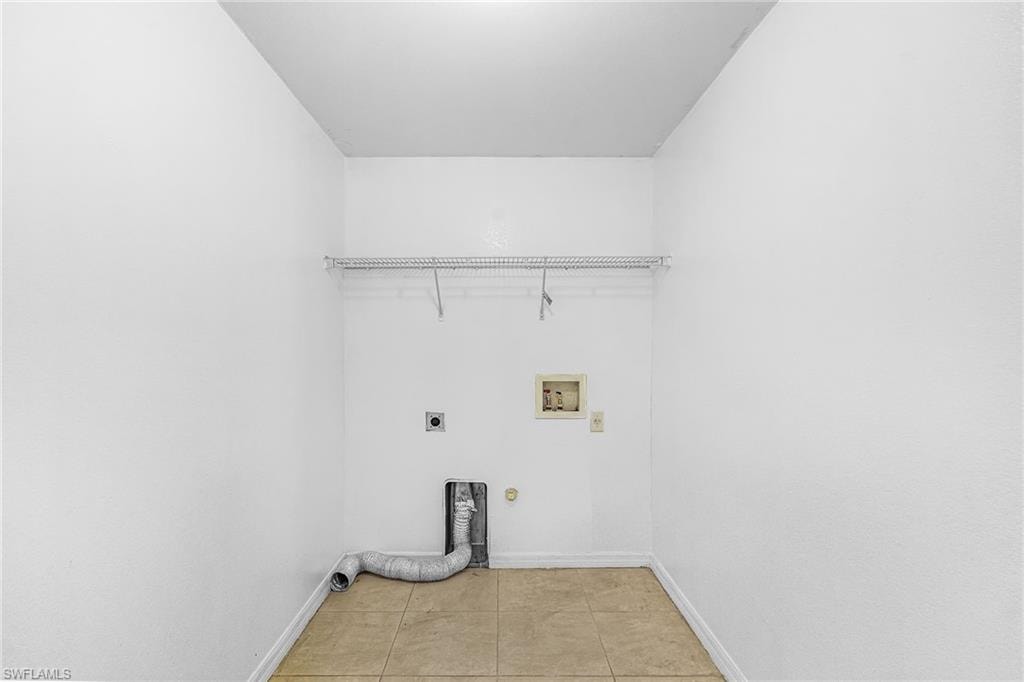 Laundry area featuring a wire shelf, utility hookups, and tiled flooring