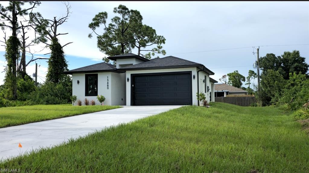 Contemporary stucco exterior with a dark shingle roof, black garage door, and a concrete driveway