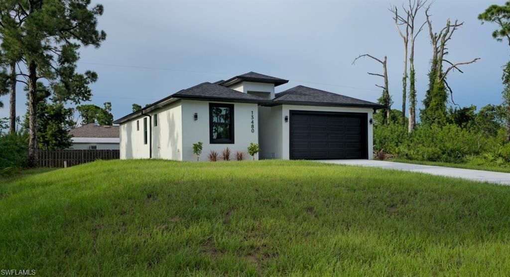 Contemporary stucco exterior with a black garage door, dark-framed windows, and a concrete driveway