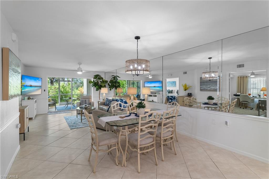 Open-concept living area with tile flooring and a mirrored accent wall