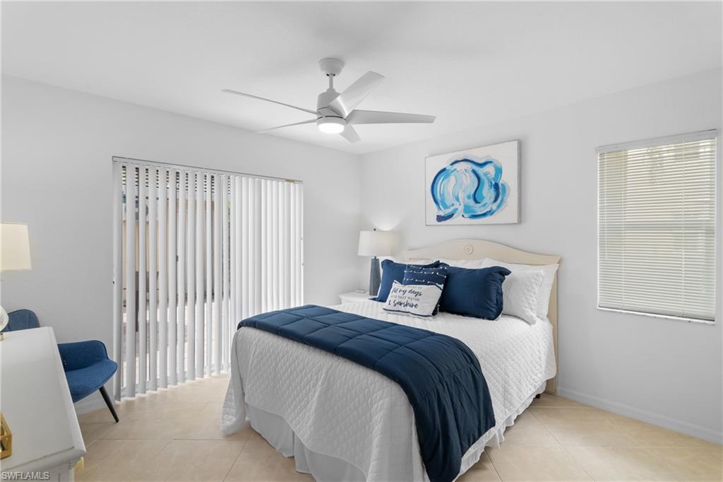 Neutral wall color, ceiling fan with integrated lighting, tiled flooring, window with horizontal blinds, vertical blinds on sliding glass door