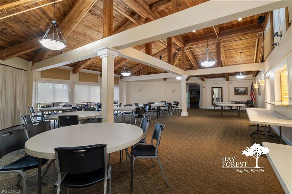 Spacious gathering area featuring exposed wood beam ceilings, recessed lighting, and multiple pendant light fixtures