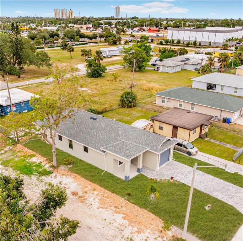 Modern single-story residence featuring a gabled roof with architectural shingles, situated on an expansive lot with mature landscaping and established trees