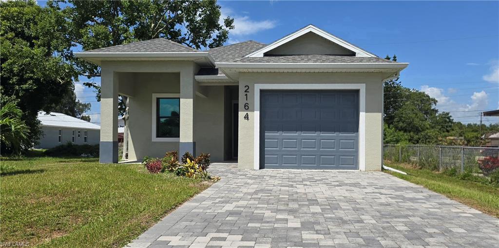 Contemporary single-story residence with a covered entryway, attached single-car garage, and a paver driveway
