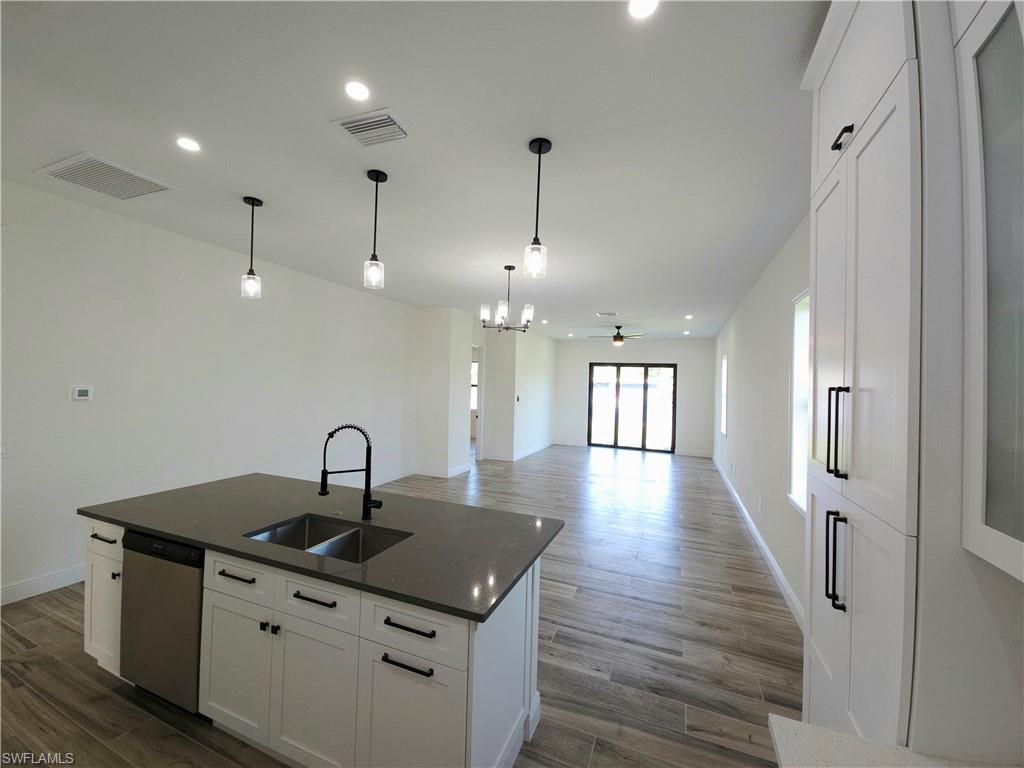 Kitchen island with a dual basin sink, black gooseneck faucet, and integrated dishwasher