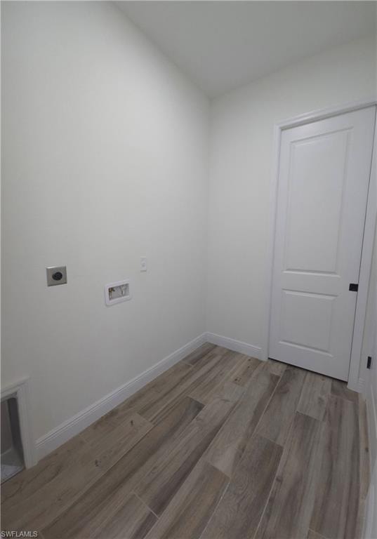 Wood-finish tile flooring, white walls, and a white two-panel door with black hardware