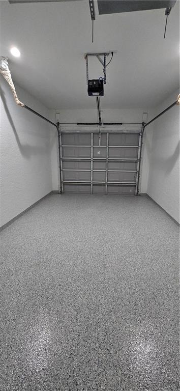 Epoxy-coated flooring, white painted walls, ceiling-mounted lighting, and a roll-up garage door