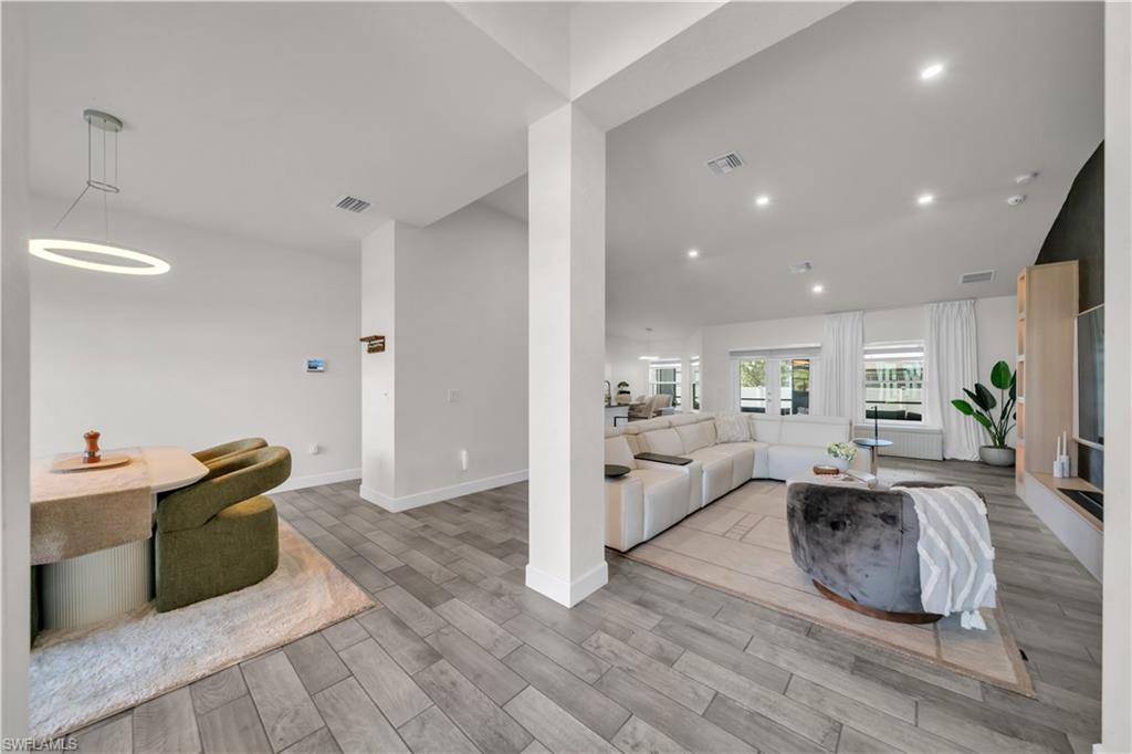 Recessed lighting illuminates wood-finish flooring throughout