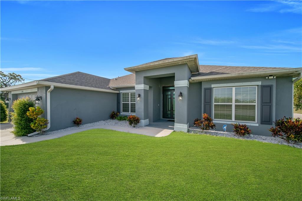 Contemporary single-story exterior with a covered entry, stucco finish, and an asphalt shingle roof