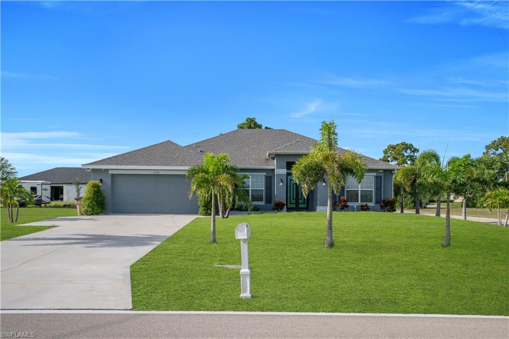 Contemporary ranch-style exterior with a gray facade, dark shingles, and a two-car garage