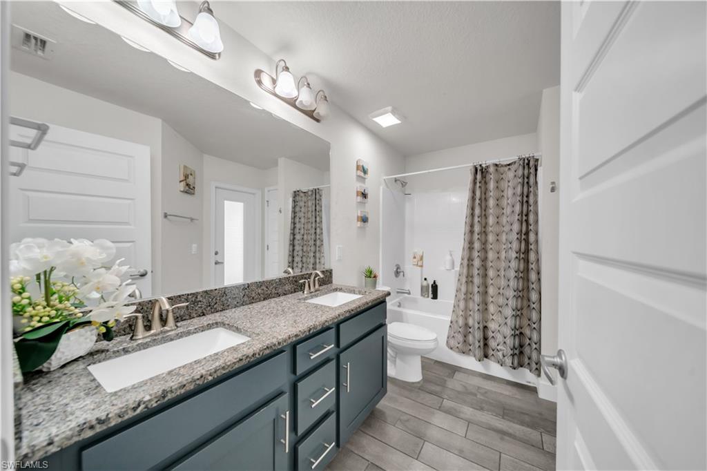 Double vanity with granite-style countertop, dual undermount sinks, and brushed nickel fixtures
