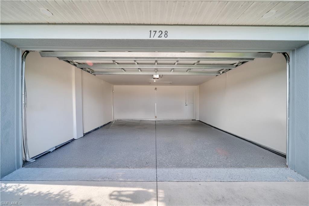 Two-car garage featuring an epoxy-coated concrete floor, painted walls, and overhead lighting