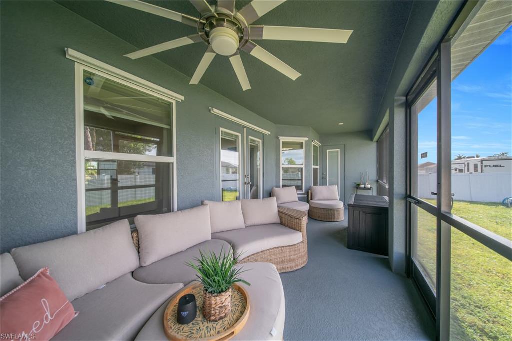 Screened outdoor living area featuring a ceiling fan, multiple windows, and a fully enclosed space