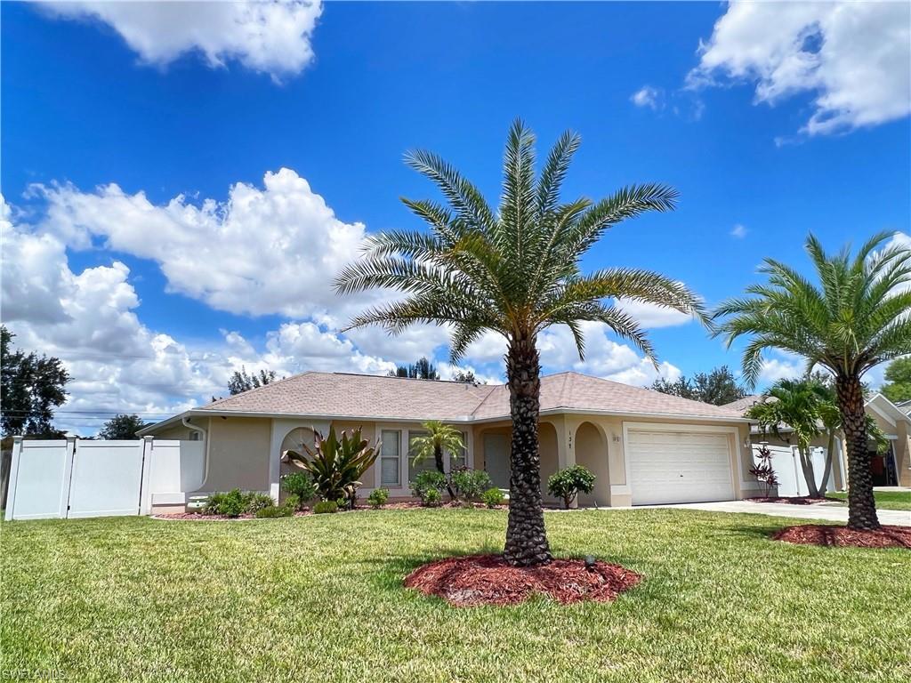 Ranch-style house featuring stucco siding, an attached garage, concrete driveway, and a gate
