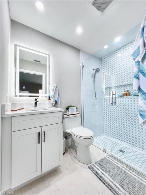 Bathroom with vanity, a shower stall, and recessed lighting