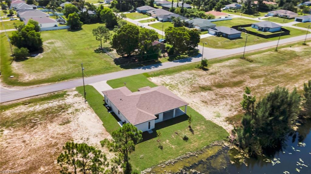 Single-story residence with a brown shingle roof, covered patio, and attached concrete driveway
