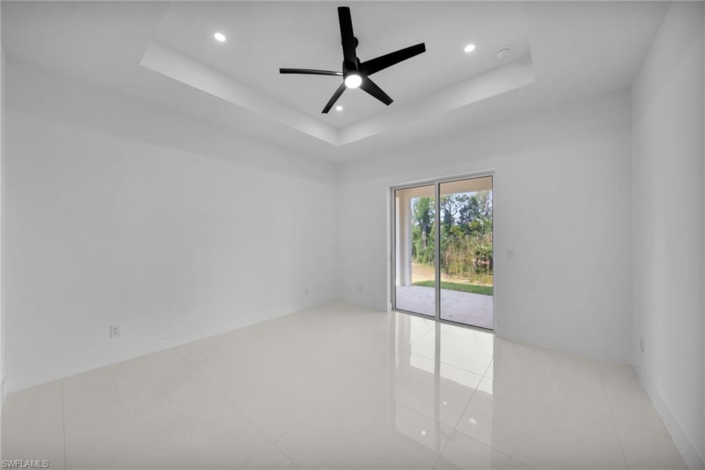 Primary bedroom: tray ceiling with recessed lighting and ceiling fan