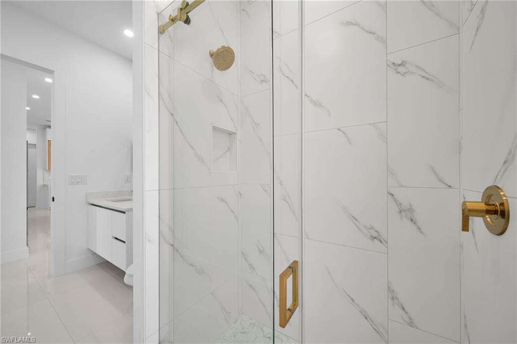 Bathroom #2: Glass-enclosed shower with gold-toned fixtures and a built-in niche