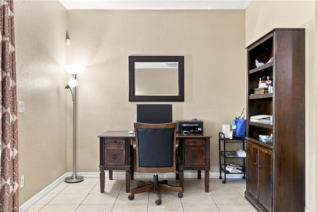 Textured wall finish, tiled flooring, built-in shelving, and recessed lighting