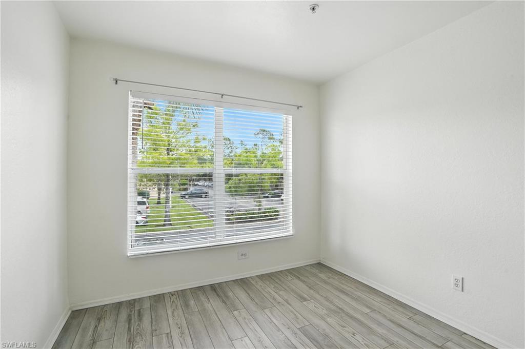 Empty room with wood finished floors and fire sprinkler in ceiling