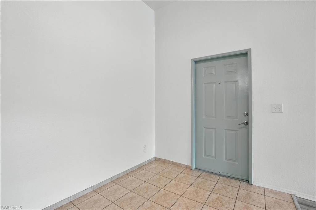 Spare room with baseboards and light tile patterned flooring
