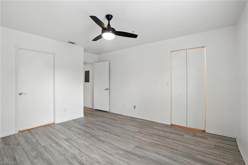 Unfurnished bedroom featuring light wood-style flooring, electric panel, and ceiling fan