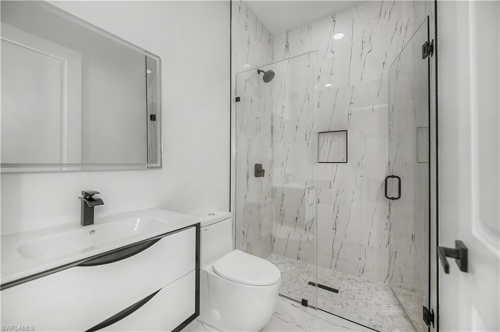 Modern vanity with integrated sink, matte black faucet, and frameless mirror