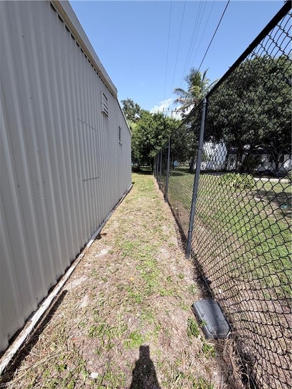 Corrugated metal siding with a chain-link fence