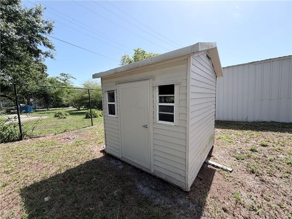 Exterior storage shed with two windows, a single entry door, and horizontal siding