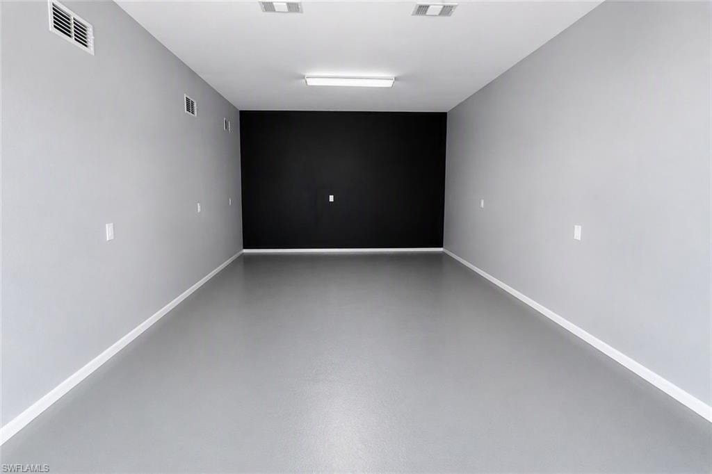 Recessed lighting fixtures, grey painted walls, white trim, and a black accent wall
