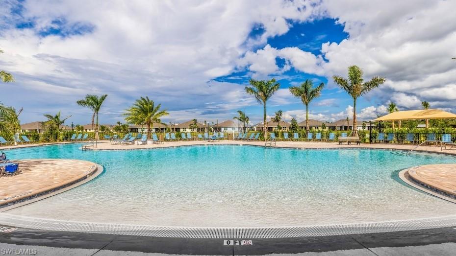 Expansive resort-style pool with a gradual entry, surrounded by a paved deck
